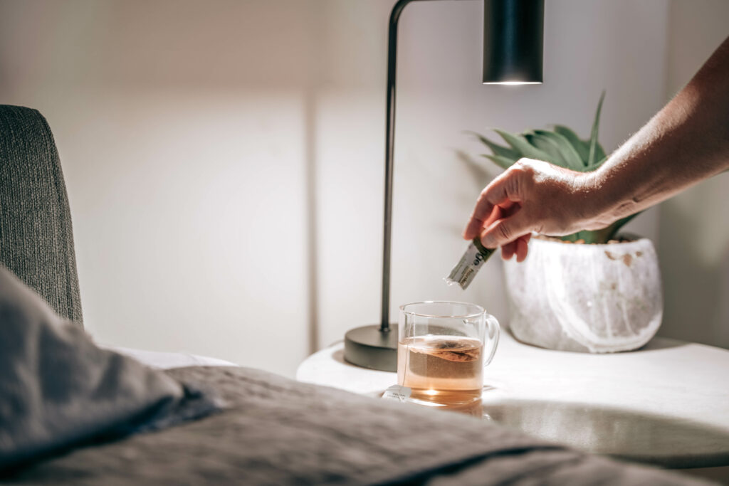 Fringe CBD isolate powder for sleep, tea on the bedside table with Fringe CBD packet.